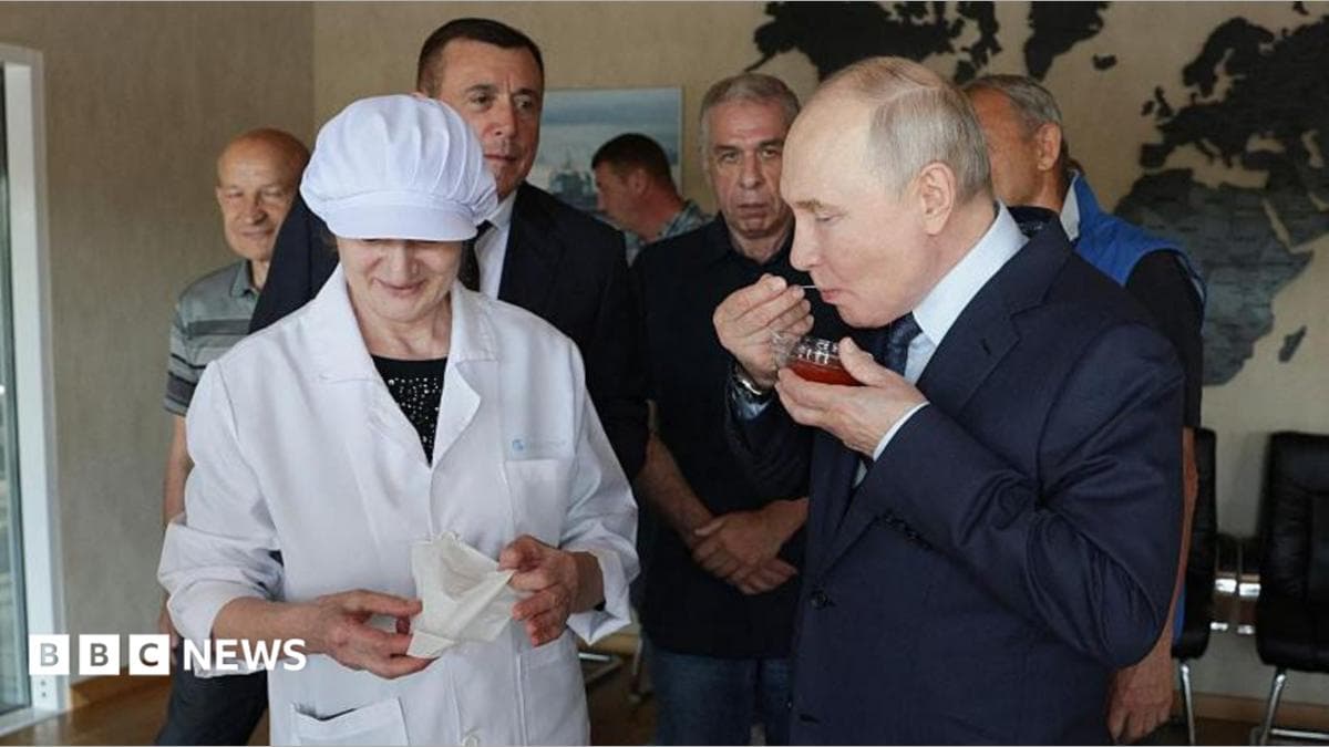 Russia's President Vladimir Putin tastes caviar as he visits the Yasny fish processing factory on Iturup, known in Japan as Etorofu