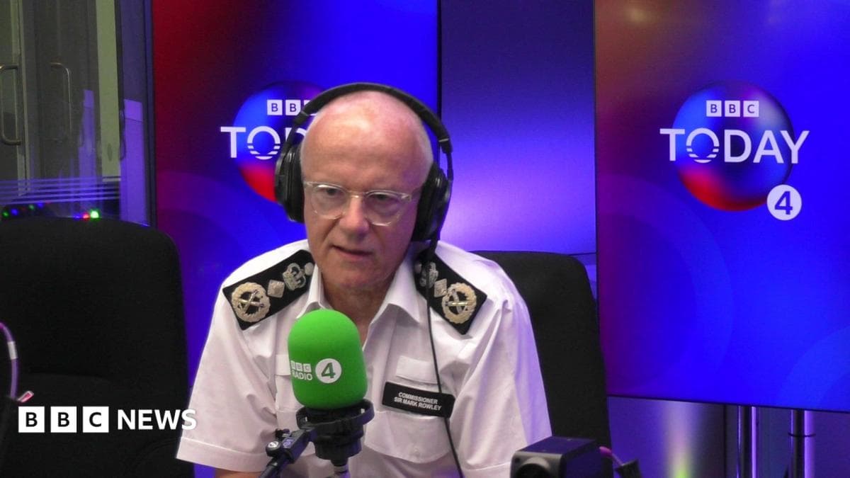 Mark Rowley wears a uniform and sits in the Today programme studio behind a microphone.