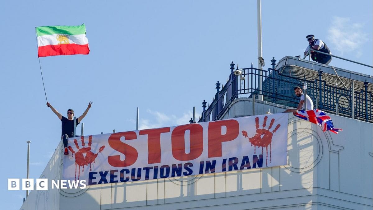 Protesters hold a banner saying "stop executions in Iran" and wave an Iranian flag during a demonstration on the roof of the Trocadero, overlooking Piccadilly Circus, central London (30 July 2026)