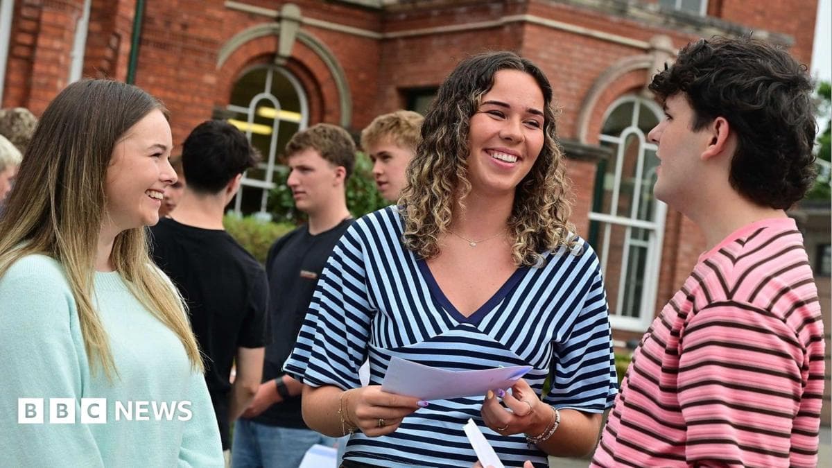 A group of young people outside a red-brick building - there is a girl in a light green top to the left, she is smiling broadly and has long brown hair; a girl in the middle has a stripey blue top and shoulder-length curly hair, she is mid-conversation and facing towards a man on the right who has a pink and black striped top and short dark hair