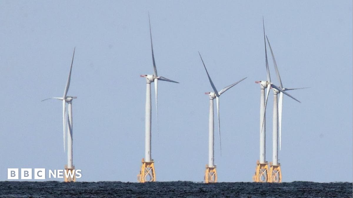 Five wind turbines mounted on yellow metal structures embedded into the sea bed at the Block Island Wind Farm off the coast of Block Island, RI.