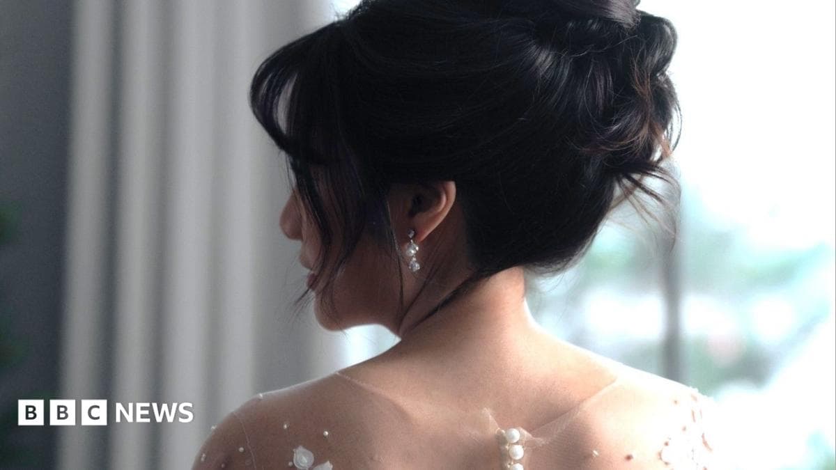 A bride with her in an updo looks over her shoulder.