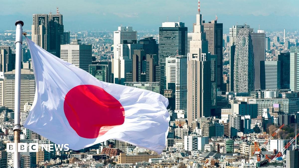 A Japanese flag flies in front of the Tokyo skyline