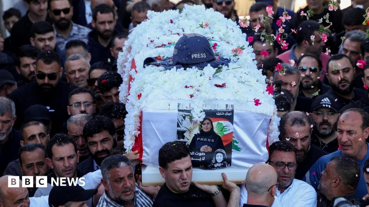 Flowers are thrown over the coffin of journalist Amal Khalil, who was killed in an Israeli strike, as mourners carry it during her funeral in Baisariyeh, Lebanon (23 April 2026)