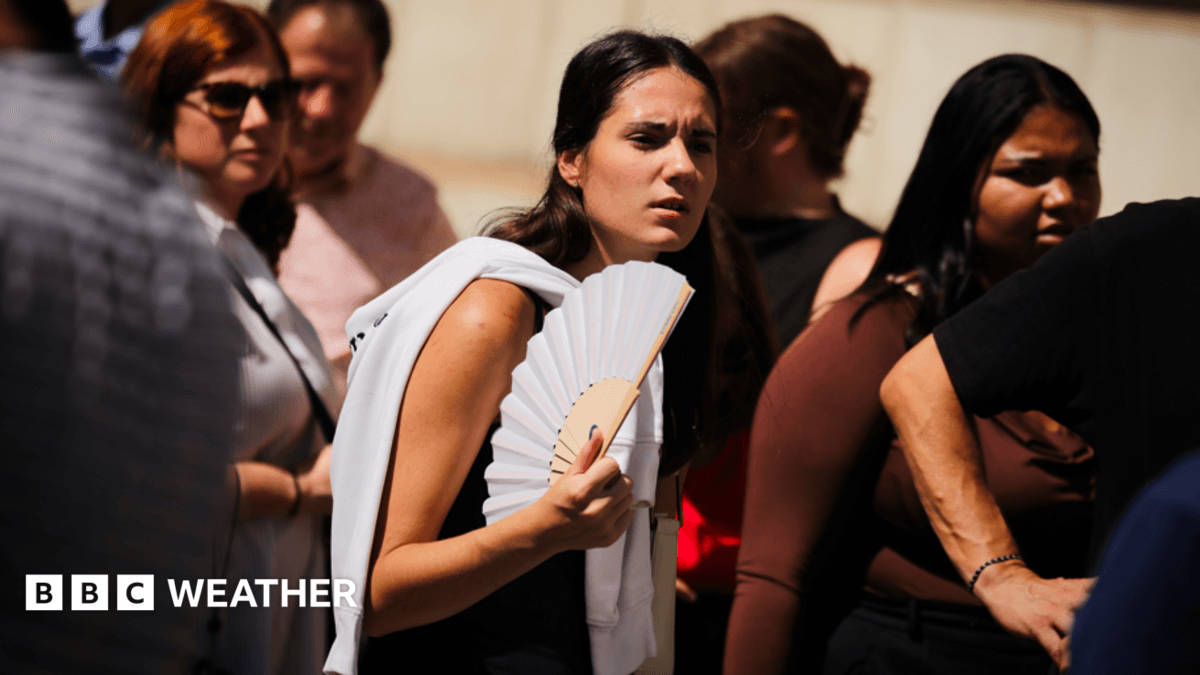 A young woman fans herself in the sunshine on a hot day